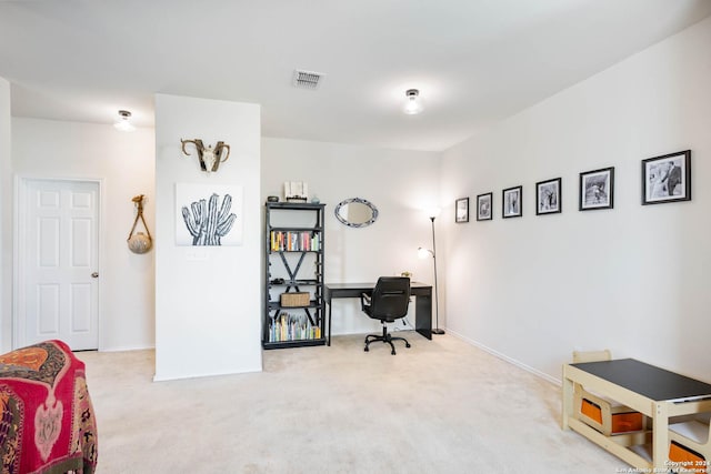 office space featuring baseboards, visible vents, and light colored carpet