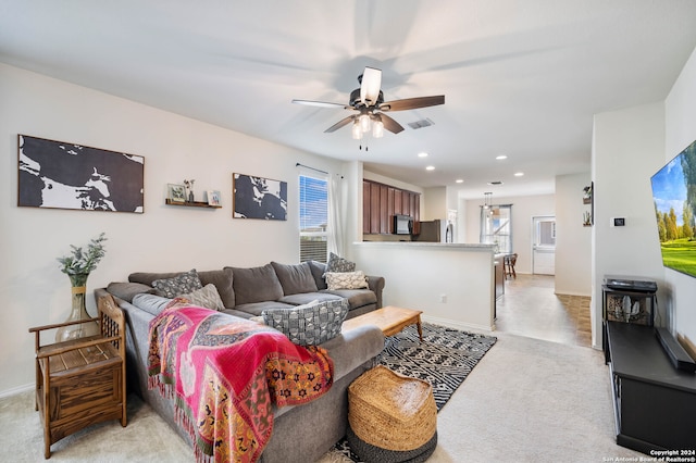 living room with a wealth of natural light, light colored carpet, and ceiling fan