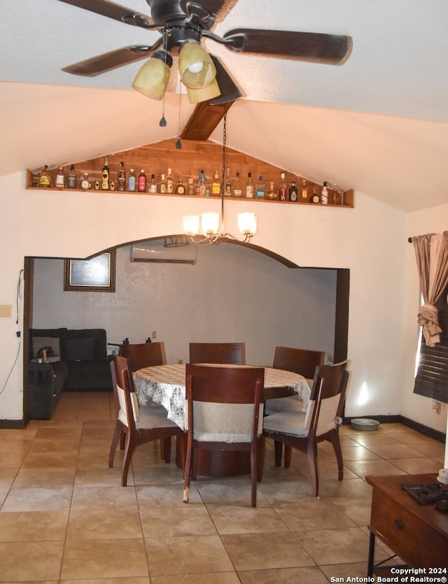 dining room with tile patterned floors, lofted ceiling, and ceiling fan with notable chandelier