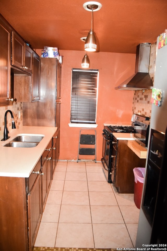 kitchen with range hood, light tile patterned floors, stainless steel appliances, pendant lighting, and sink