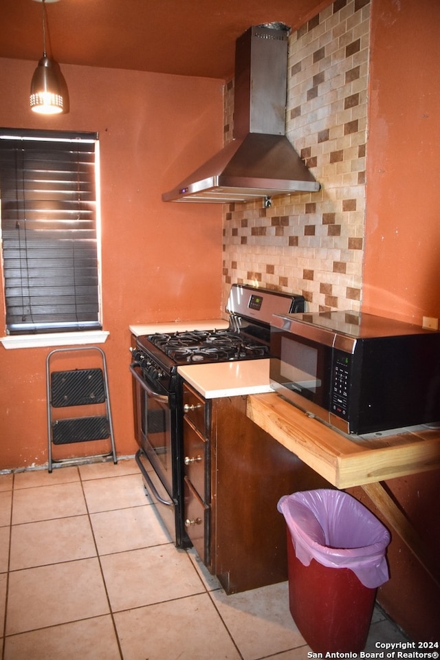 kitchen with stainless steel appliances, wall chimney exhaust hood, pendant lighting, decorative backsplash, and light tile patterned floors