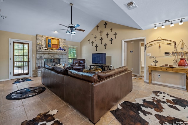 tiled living room featuring a stone fireplace, high vaulted ceiling, and ceiling fan