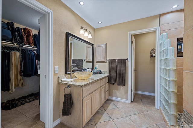 bathroom with vanity, a textured ceiling, and tile patterned floors