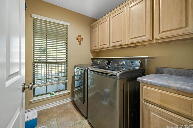 washroom featuring cabinets and washer and clothes dryer