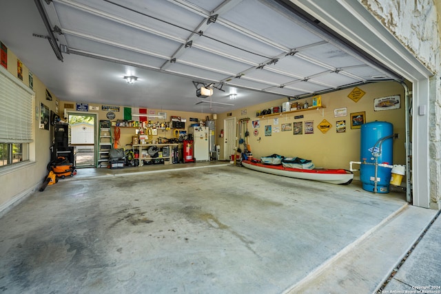 garage with a garage door opener, a workshop area, and white refrigerator