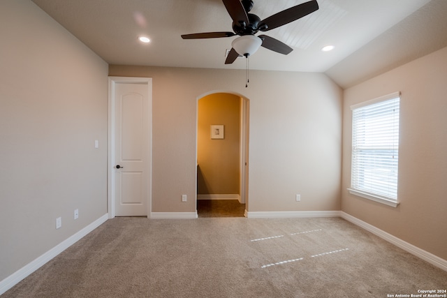 spare room with light carpet, lofted ceiling, and ceiling fan