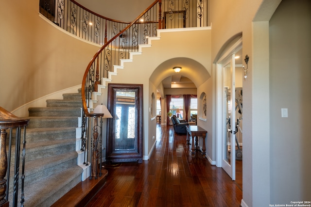 foyer with a high ceiling, dark wood-type flooring, and french doors