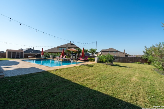 view of pool with a patio, a storage shed, and a yard