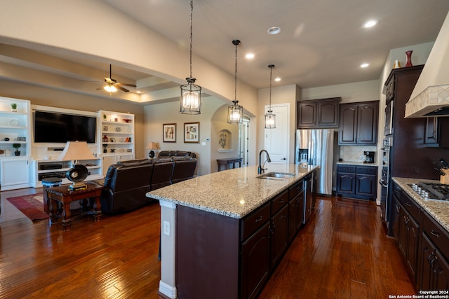 kitchen featuring dark brown cabinetry, sink, pendant lighting, and dark hardwood / wood-style flooring