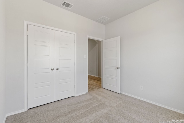unfurnished bedroom with baseboards, visible vents, a closet, and carpet