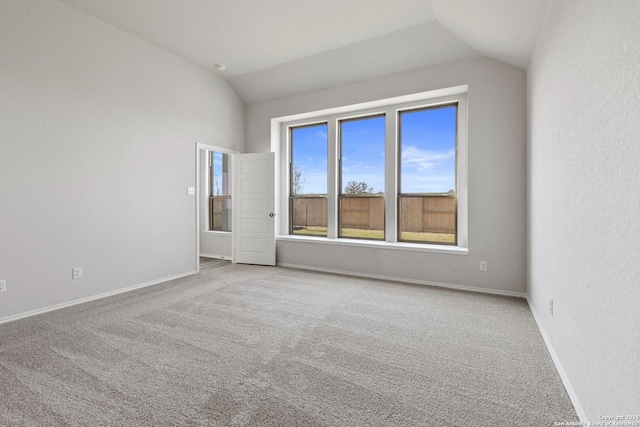 unfurnished room featuring baseboards, carpet, and lofted ceiling