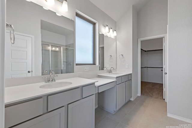 bathroom featuring two vanities, a shower stall, tile patterned flooring, and a sink