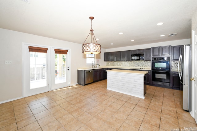 kitchen with a kitchen island, sink, black appliances, decorative light fixtures, and tasteful backsplash