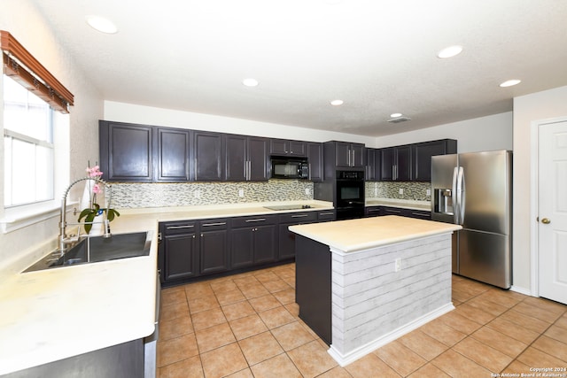 kitchen with tasteful backsplash, a kitchen island, light tile patterned flooring, black appliances, and sink