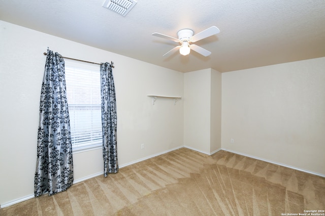 spare room featuring carpet, a textured ceiling, and ceiling fan