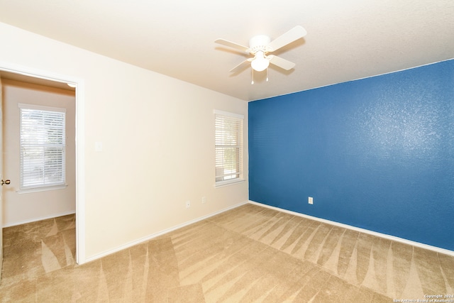 empty room featuring carpet floors and ceiling fan