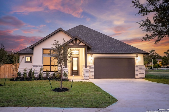 view of front of home with a yard and a garage