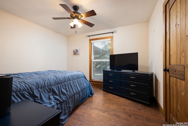 bedroom with dark hardwood / wood-style flooring and ceiling fan