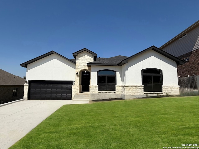 view of front of property with a garage and a front lawn