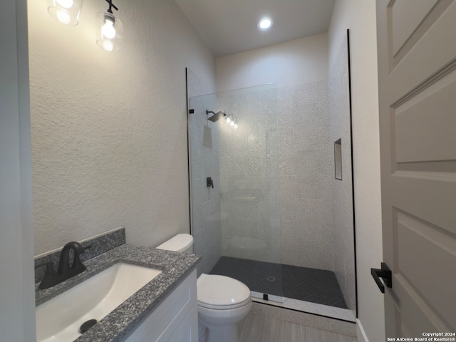 bathroom with vanity, toilet, and tiled shower