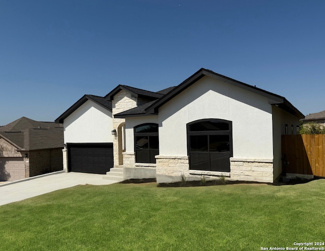 view of front of home with a garage and a front lawn