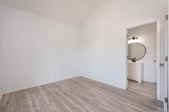 23238 Copper Canyon Dr, Elmendorf, TX 78112 - unfurnished bedroom with light wood-type flooring, lofted ceiling, baseboards, and a sink