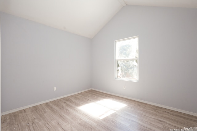 empty room with lofted ceiling and light wood-type flooring