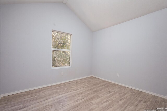 23238 Copper Canyon Dr, Elmendorf, TX 78112 - empty room featuring light wood-style floors, vaulted ceiling, and baseboards