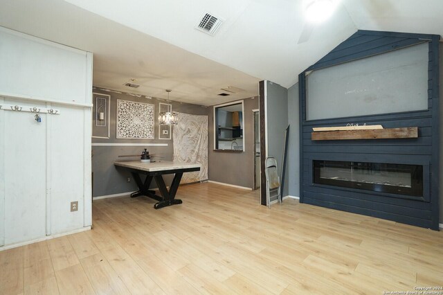 23238 Copper Canyon Dr, Elmendorf, TX 78112 - interior space featuring light wood-type flooring, baseboards, an inviting chandelier, lofted ceiling, and a fireplace