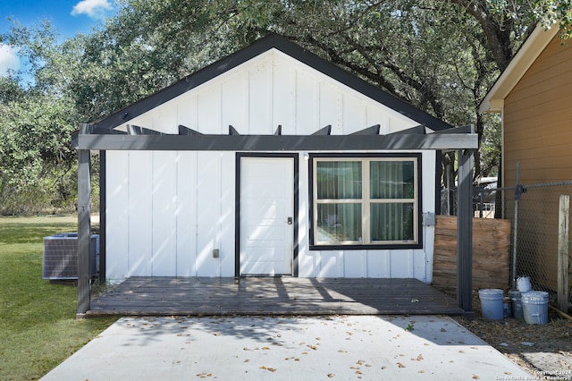 view of outdoor structure with cooling unit and a yard