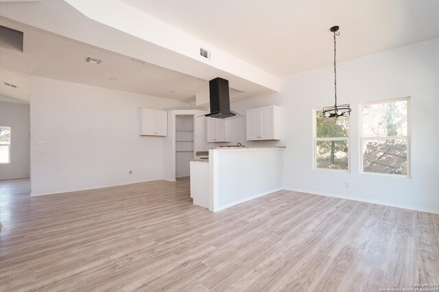 23238 Copper Canyon Dr, Elmendorf, TX 78112 - unfurnished living room featuring light wood-type flooring, plenty of natural light, and a chandelier