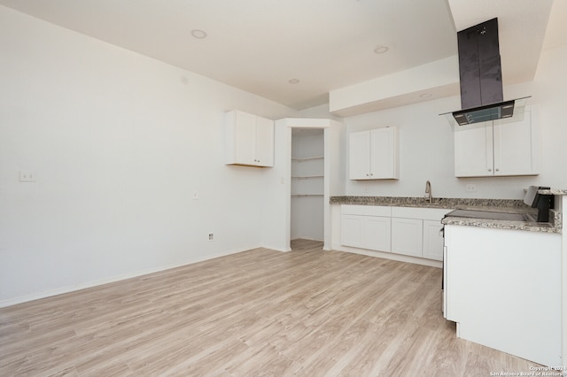 kitchen with white cabinets, light stone counters, light hardwood / wood-style floors, sink, and ventilation hood