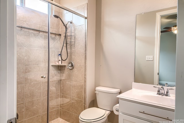 bathroom featuring vanity, toilet, walk in shower, and ceiling fan