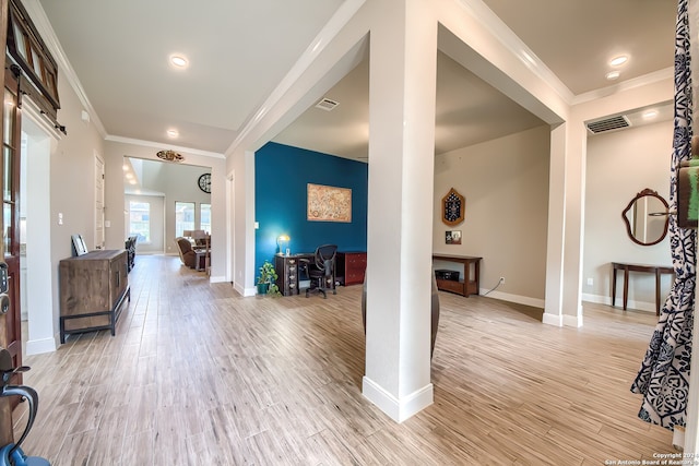 entrance foyer featuring ornamental molding and light hardwood / wood-style flooring