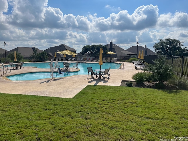 view of pool featuring a yard and a patio