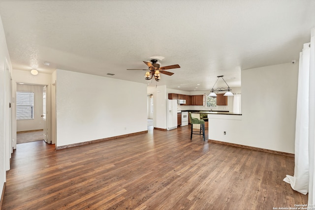 unfurnished living room with dark hardwood / wood-style floors, a textured ceiling, sink, and ceiling fan