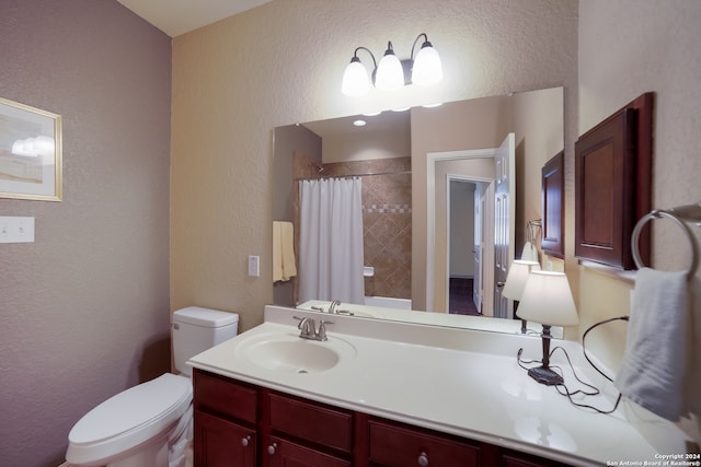 bathroom with toilet, curtained shower, and vanity