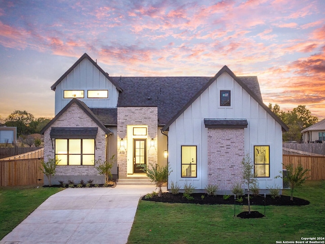 modern farmhouse style home featuring a lawn