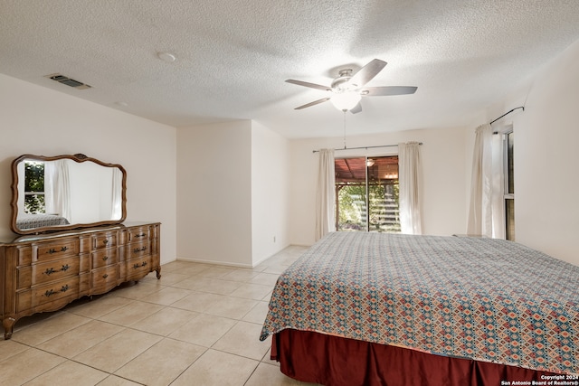 bedroom featuring ceiling fan, a textured ceiling, and light tile patterned flooring