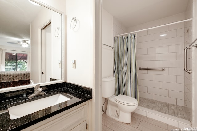 bathroom with vanity, ceiling fan, toilet, and walk in shower