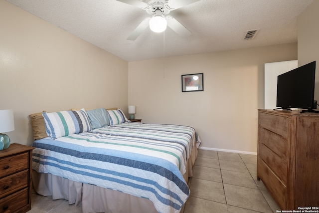 tiled bedroom featuring ceiling fan and a textured ceiling