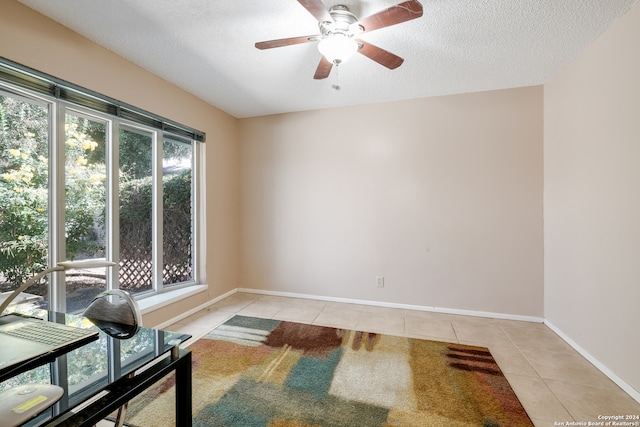 interior space with ceiling fan and a textured ceiling