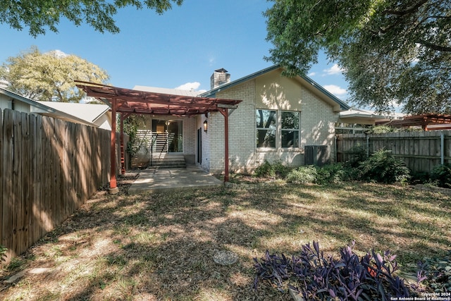 back of house featuring central AC, a yard, and a pergola