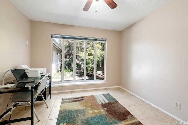 tiled office space with a textured ceiling and ceiling fan