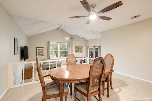 dining room with ceiling fan, lofted ceiling with beams, and light tile patterned flooring