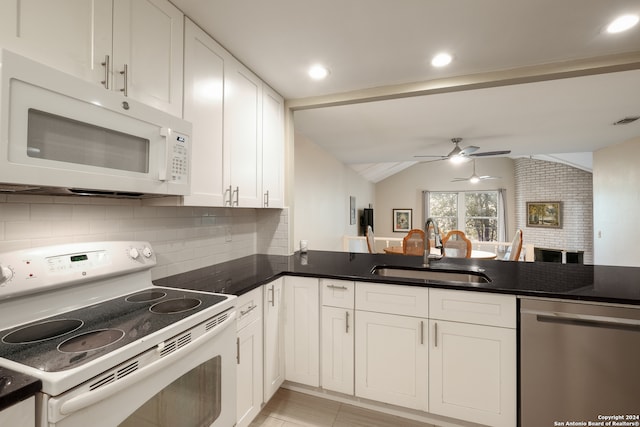 kitchen featuring sink, vaulted ceiling, white cabinets, white appliances, and ceiling fan