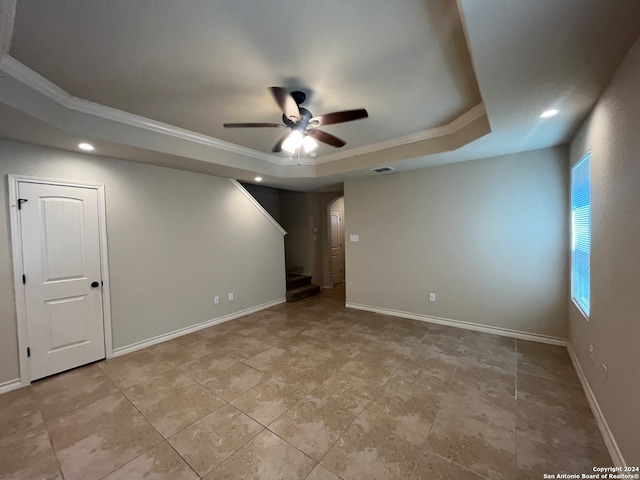 empty room featuring ornamental molding, a tray ceiling, and ceiling fan