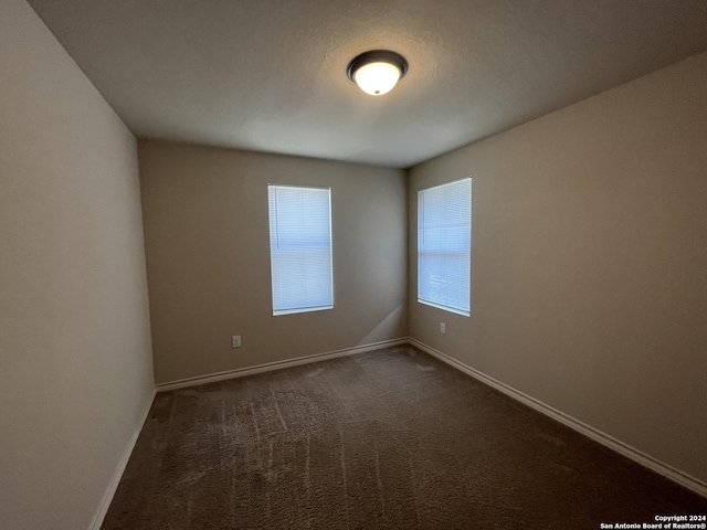 6614 Mia Way, San Antonio, TX 78233 - empty room featuring baseboards and dark colored carpet