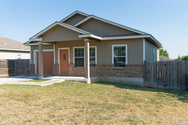 view of front facade featuring covered porch, a garage, and a front yard