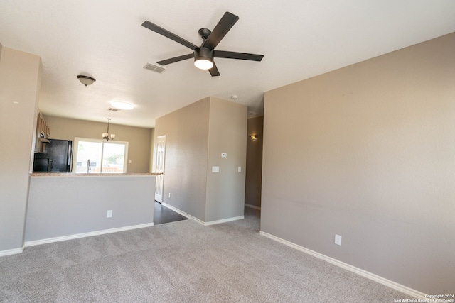 interior space featuring carpet flooring, sink, and ceiling fan with notable chandelier